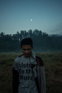 Portrait of young man standing on field