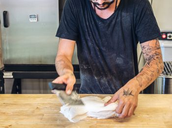 Midsection of man preparing food at table