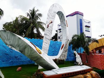 Woman by swimming pool against sky