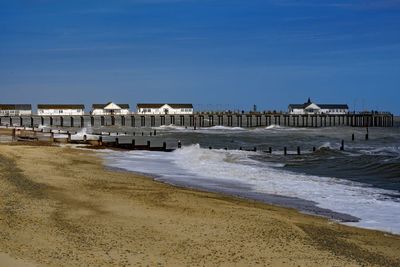 Built structure on beach by sea against sky