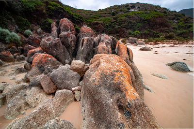 Rock formation on beach against sky