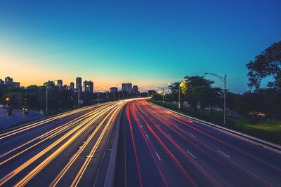 High angle view of colorful light trails on road at sunset