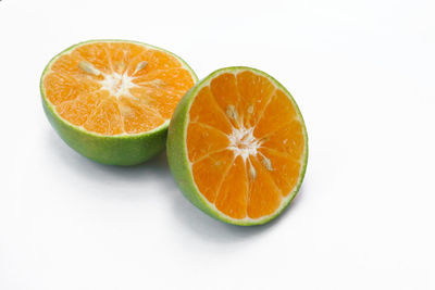 Close-up of orange slices over white background