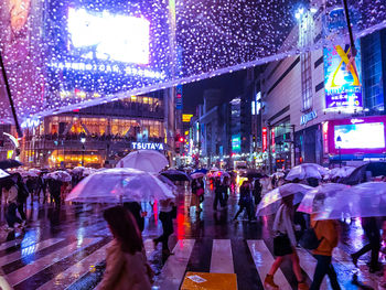 People walking in illuminated city at night