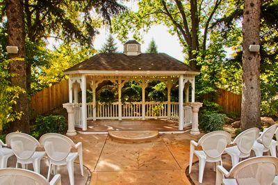 Empty chairs and table in yard against building