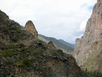 Ancient building structure on mountain against cloudy sky