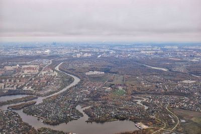 Aerial view of city against cloudy sky