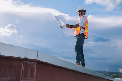 Low angle view of man standing against sky