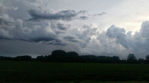 Scenic view of grassy field against cloudy sky