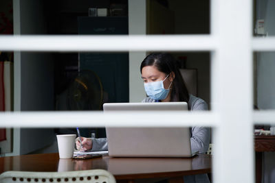  portrait of young woman wearing face mask have online class   