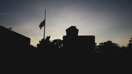 Low angle view of silhouette flag against sky