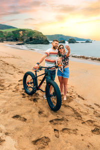 Couple with fat bike taking a selfie with their dog on the beach