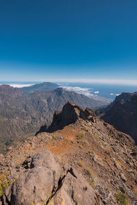 Scenic view of mountains against blue sky