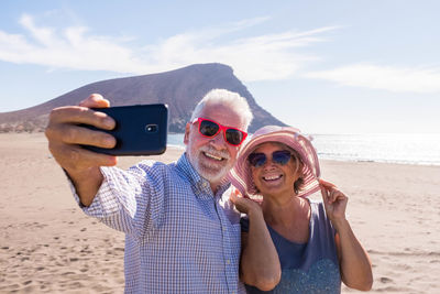 Portrait of man photographing camera on beach