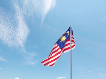 Low angle view of malaysian flag against blue sky