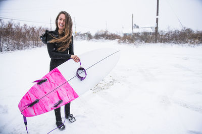 Woman going surfing during winter snow