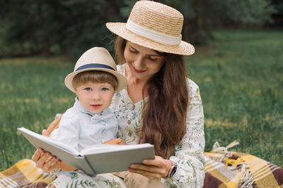 Beautiful mother with boy sitting at park