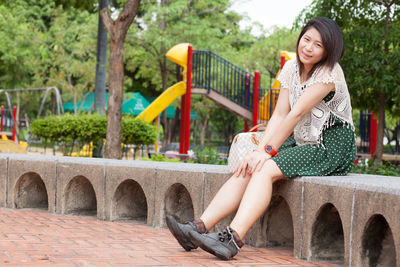 Portrait of smiling woman sitting in park