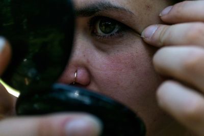 Close-up of young woman holding powder compact