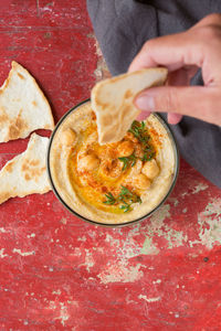 Close-up of hand holding pizza in bowl