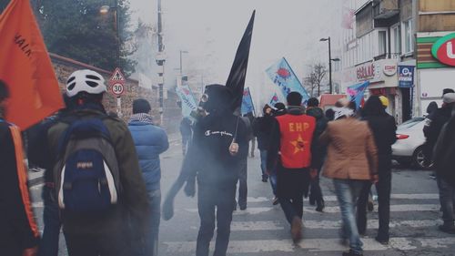 Rear view of people walking on city street