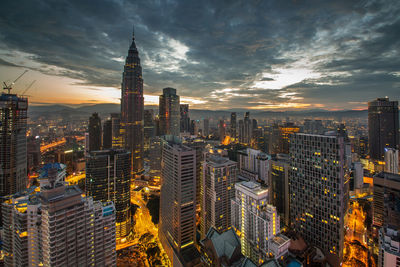 Aerial view of illuminated city buildings during sunset