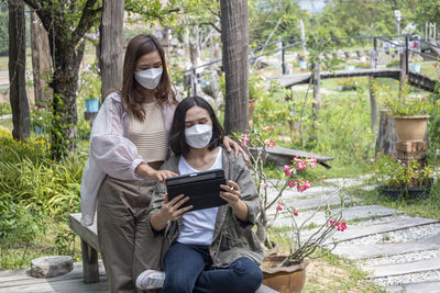 Rear view of businesswoman using tablet while standing in park