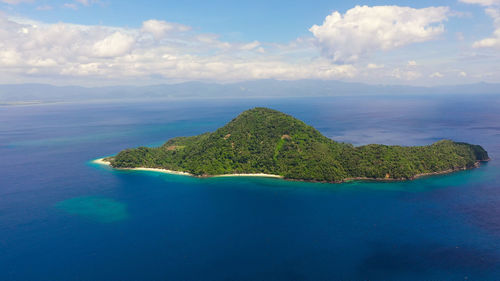 Seascape with a green island. atulayan island, camarines sur, philippines. blue sea with islands