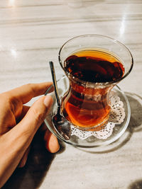 Midsection of person holding tea cup on table