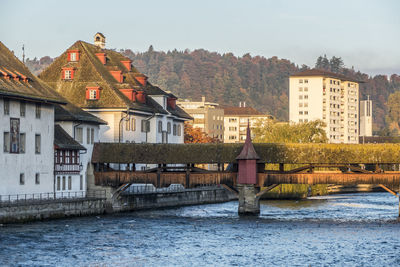 Bridge over river against buildings in city