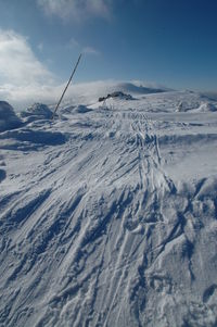 Scenic view of snow covered land against sky