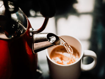 Close-up of pouring of hot water into a cup of coffee