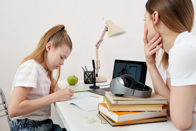 Mother helping daughter with homework