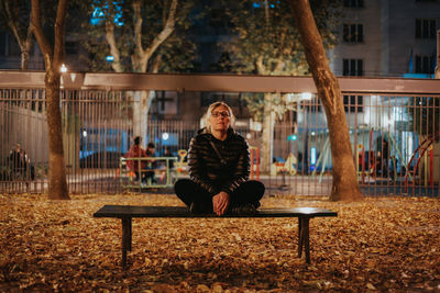 Full length of woman standing on bench