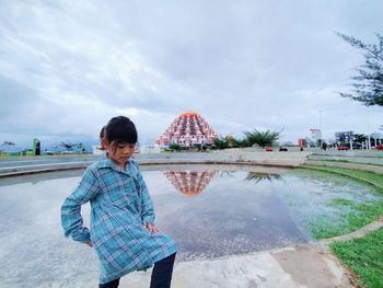 Woman standing in water against sky