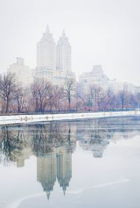 Reflection of the eldorado on calm lake in central park during winter