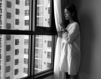 Young woman standing against wall