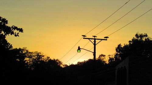 Silhouette trees against clear sky during sunset