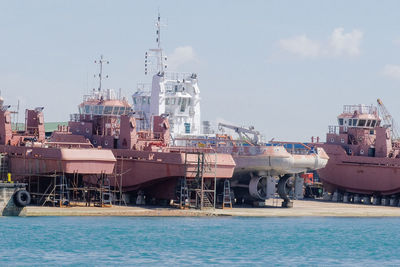 Commercial dock by sea against sky