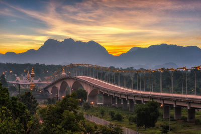 Bridge over mountain against sky during sunset