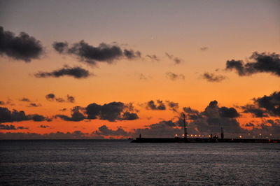 View of calm sea against cloudy sky during sunset