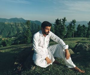 Young man looking away on field