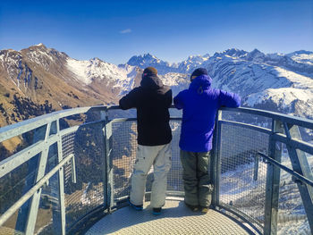 Rear view of man walking on railing