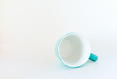 High angle view of coffee cup on table against white background
