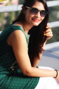 Portrait of smiling young woman wearing sunglasses