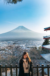 Portrait of smiling woman against mountains during winter