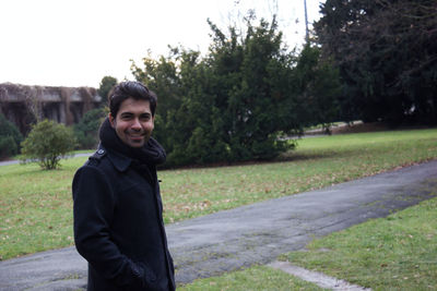 Portrait of young man standing by road