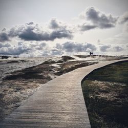 Empty road against cloudy sky