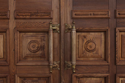 Antique massive wooden doors with large handles close-up. ancient architecture.