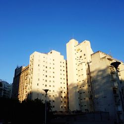 Low angle view of buildings against clear blue sky